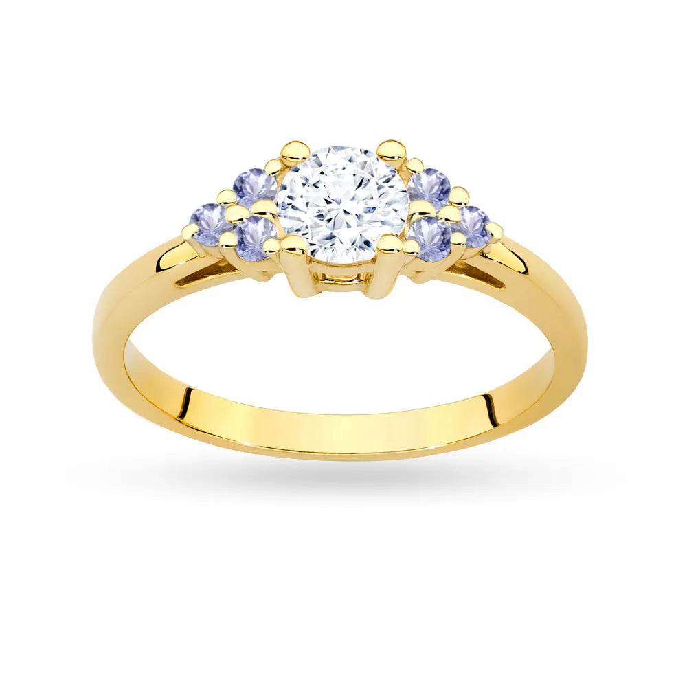 Prsteň zo žltého zlata 14k(585) s bielym zafírom 0,60 ct a 6 tanzanitmi. Je zabalený v elegantnej krabičke, ktorá je ideálna ako darček.