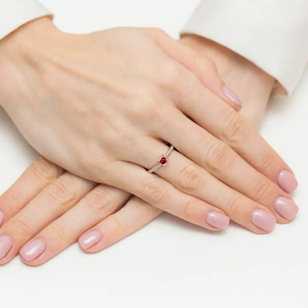 Ring aus 14 Karat Roségold mit 0,15 ct Rubin und 0,005 ct Diamanten. Verpackt in schwarzer Schachtel, Papier und Geschenktüte.