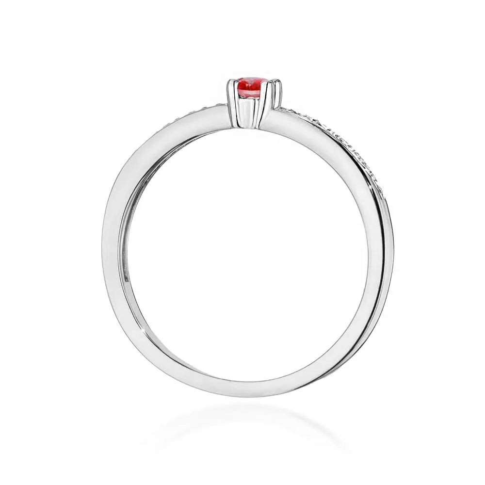 Bague en or blanc 14 carats avec rubis de 0,15 ct et diamants de 0,05 ct. Emballée dans une boîte noire, papier et sac cadeau.