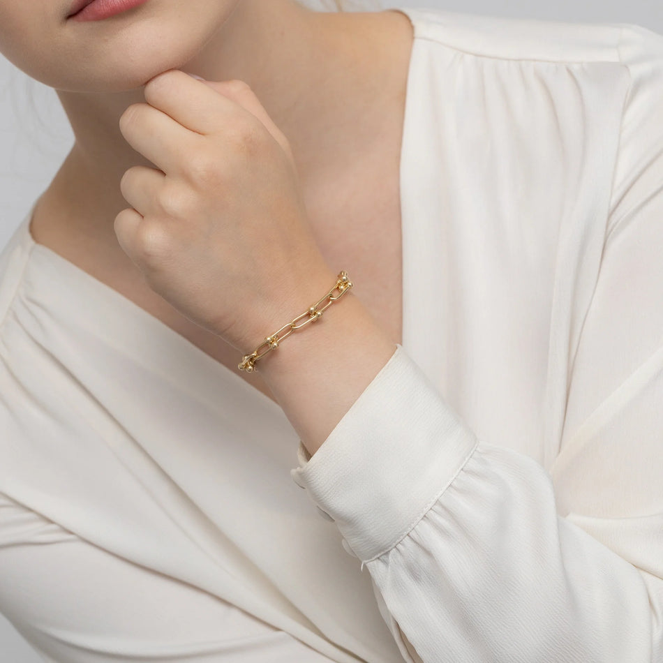 Goldenes breites Armband mit Gliedern und Perlen