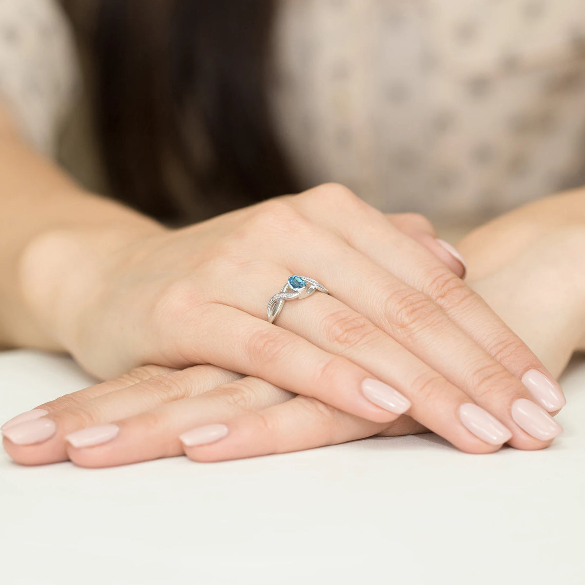 Prsten nekonečna z bílého 14k zlata s oválným topazem Swiss Blue 0,50 ct a diamanty 0,05 ct