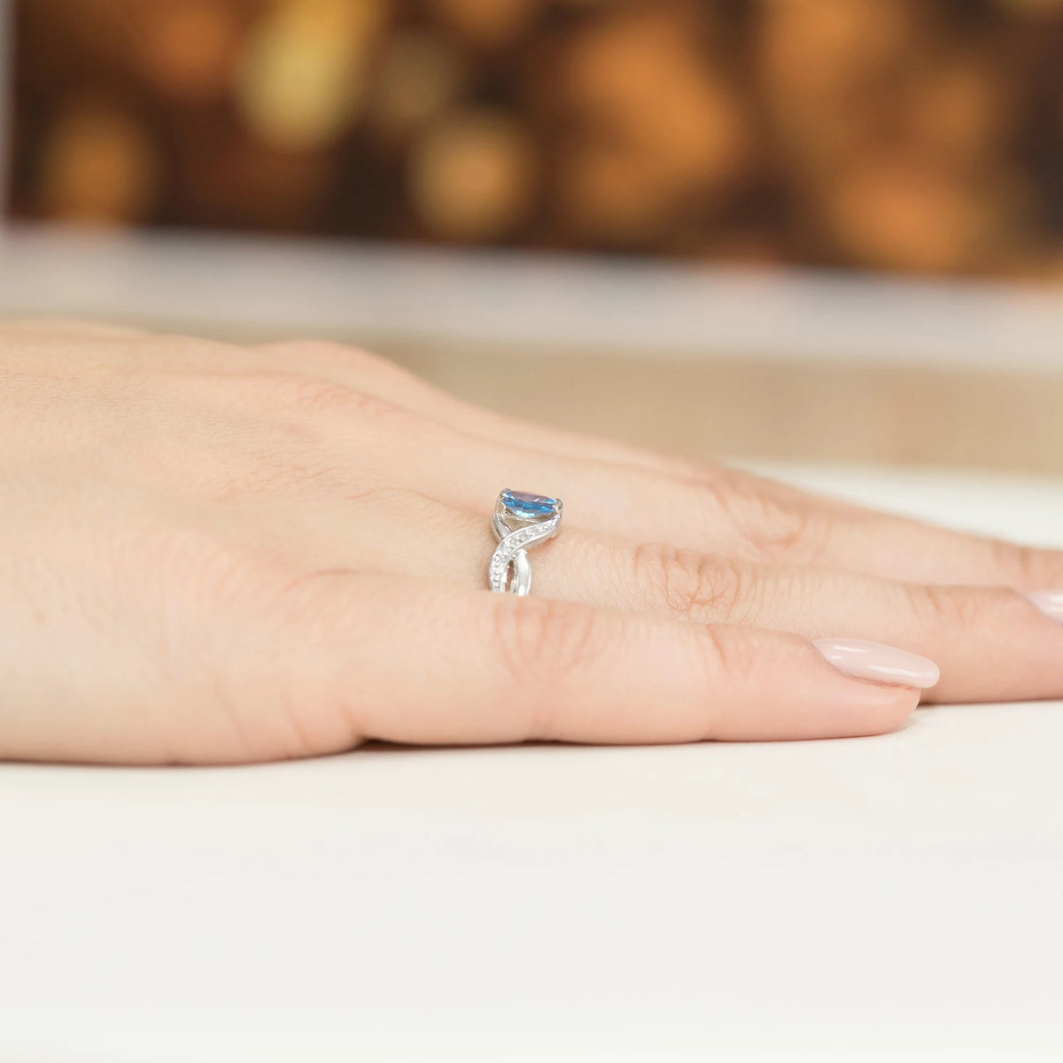 Prsten nekonečna z bílého 14k zlata s oválným topazem Swiss Blue 0,50 ct a diamanty 0,05 ct